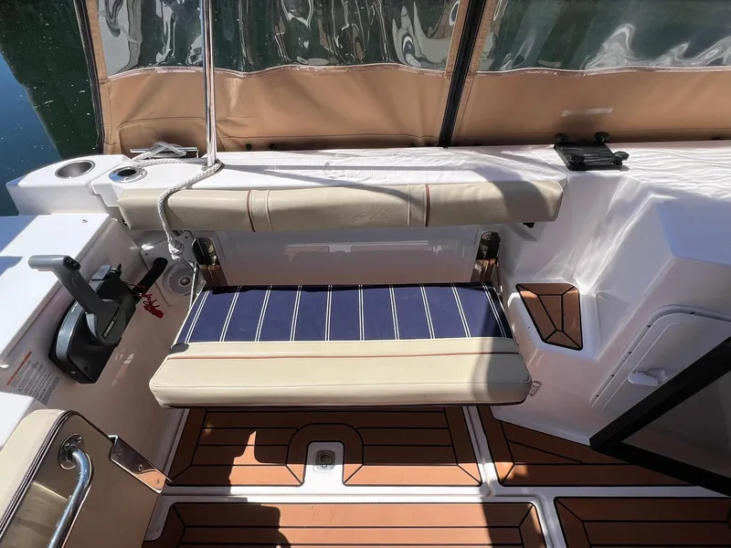 Slide: The Image of 2020 Ranger Tugs R-27 boat interior with cushioned seating and wood-patterned flooring. - 11