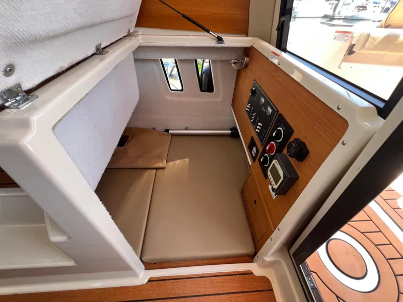 Slide: The Image of 2020 Ranger Tugs R-27 cabin interior with control panel and cushioned seating. - 14