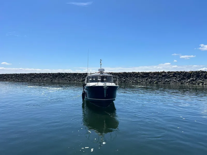 Slide: The Image of 2020 Ranger Tugs R-27 boat on calm water under clear blue sky. - 2