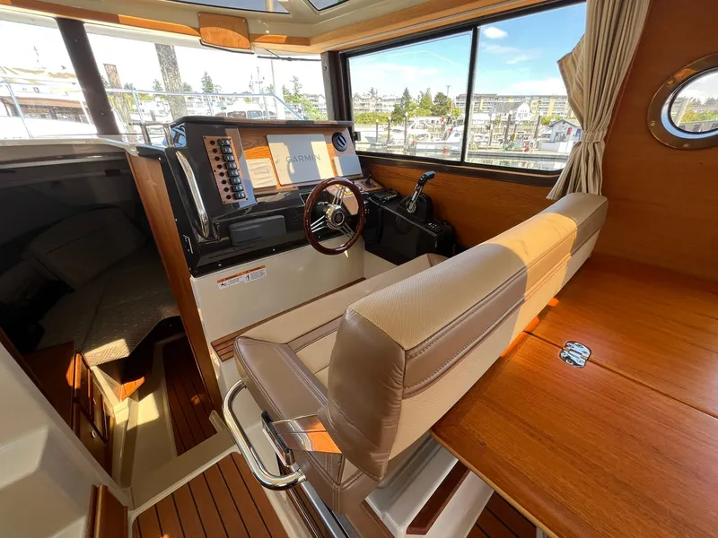 Slide: The Image of Interior of 2020 Ranger Tugs R-27 boat with helm, seating, and wood finishes. - 20