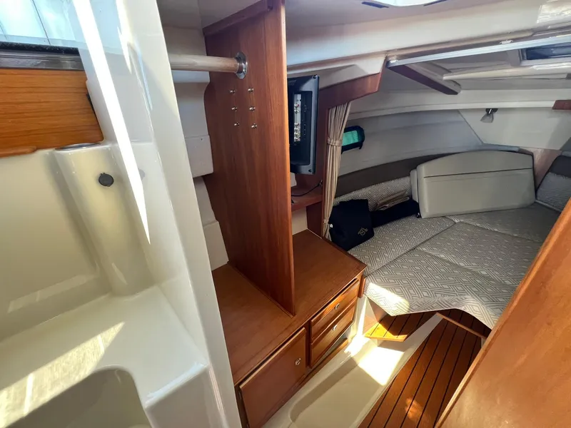 Slide: The Image of 2020 Ranger Tugs R-27 cabin interior with wood accents and cozy sleeping area. - 23