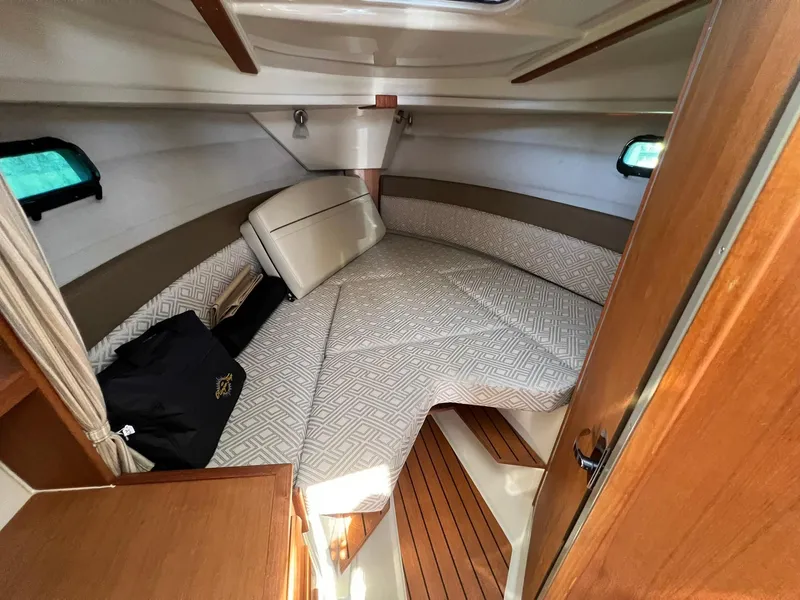 Slide: The Image of 2020 Ranger Tugs R-27 cabin interior with cozy bed and wooden accents. - 24