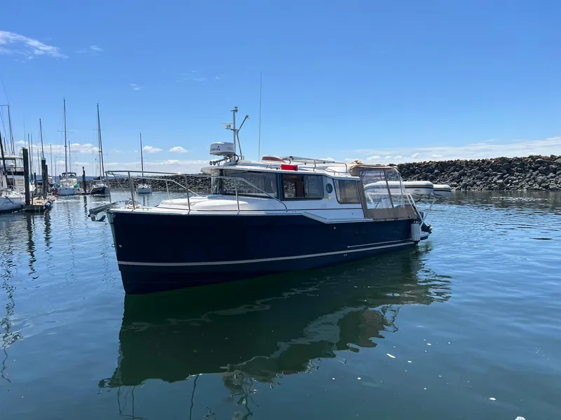 Slide: The Image of 2020 Ranger Tugs R-27 boat docked in a marina under a clear blue sky. - 3