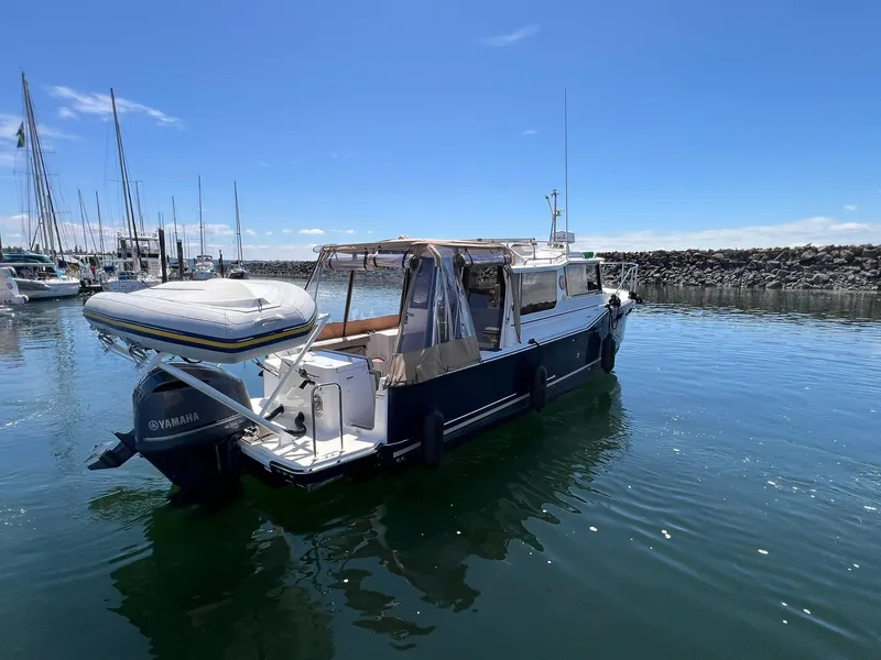 Slide: The Image of 2020 Ranger Tugs R-27 boat with Yamaha motor in a marina under clear blue sky. - 5