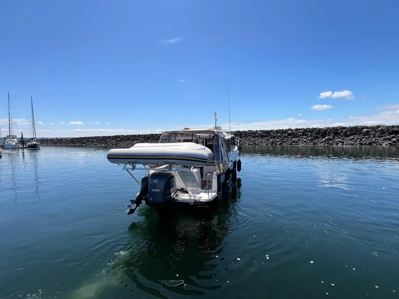 Slide: The Image of 2020 Ranger Tugs R-27 boat on calm water under clear blue sky. - 6