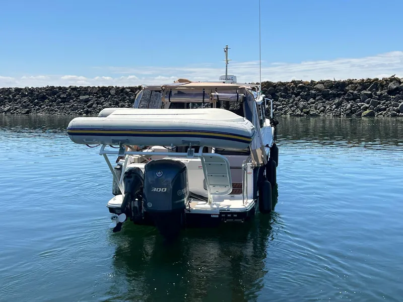 Slide: The Image of 2020 Ranger Tugs R-27 boat with outboard motor and dinghy, docked in calm waters. - 7