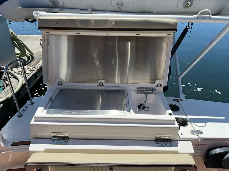 Slide: The Image of Open storage compartment on 2020 Ranger Tugs R-27 boat, docked by the water. - 9