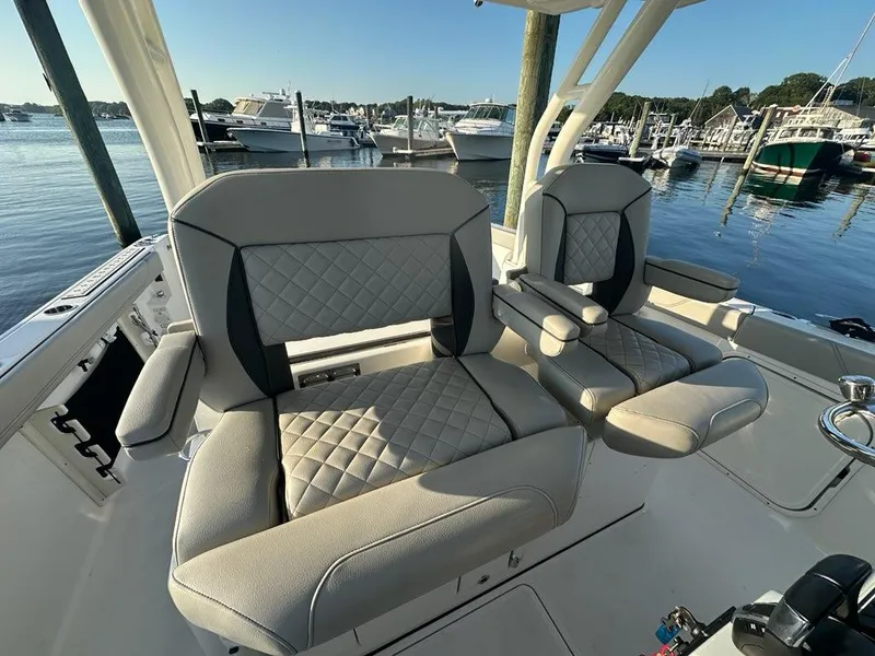 Slide: The Image of Luxury seating on 2022 Pursuit S 328 Sport boat at marina. - 10