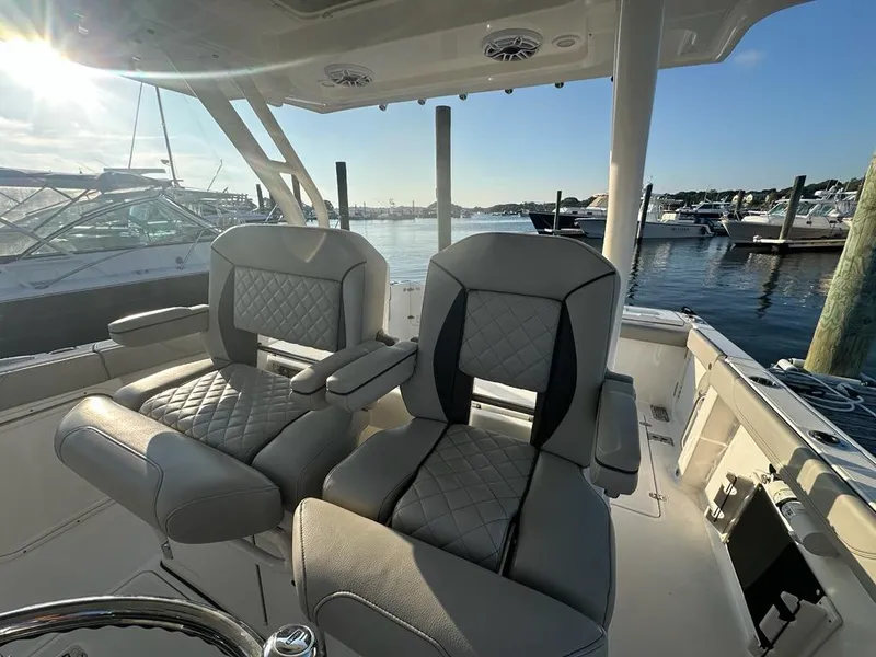 Slide: The Image of Luxurious seating on 2022 Pursuit S 328 Sport boat, docked at marina with scenic water view. - 11