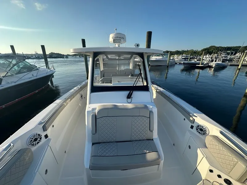 Slide: The Image of 2022 Pursuit S 328 Sport boat docked in a marina, featuring sleek design and comfortable seating. - 16