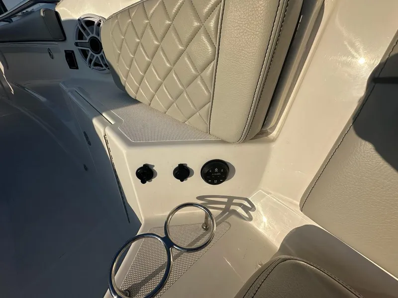 Slide: The Image of 2022 Pursuit S 328 Sport boat interior with cushioned seating and cup holders. - 17