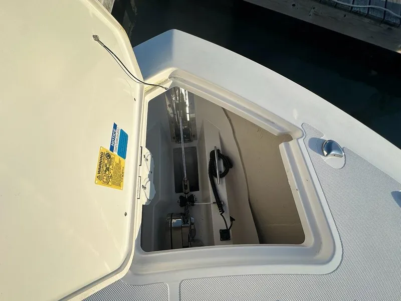 Slide: The Image of 2022 Pursuit S 328 Sport boat anchor compartment with open hatch, dockside view. - 18