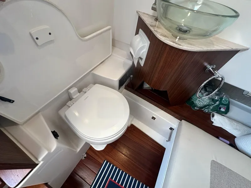 Slide: The Image of 2022 Pursuit S 328 Sport boat bathroom with modern fixtures and wooden accents. - 21