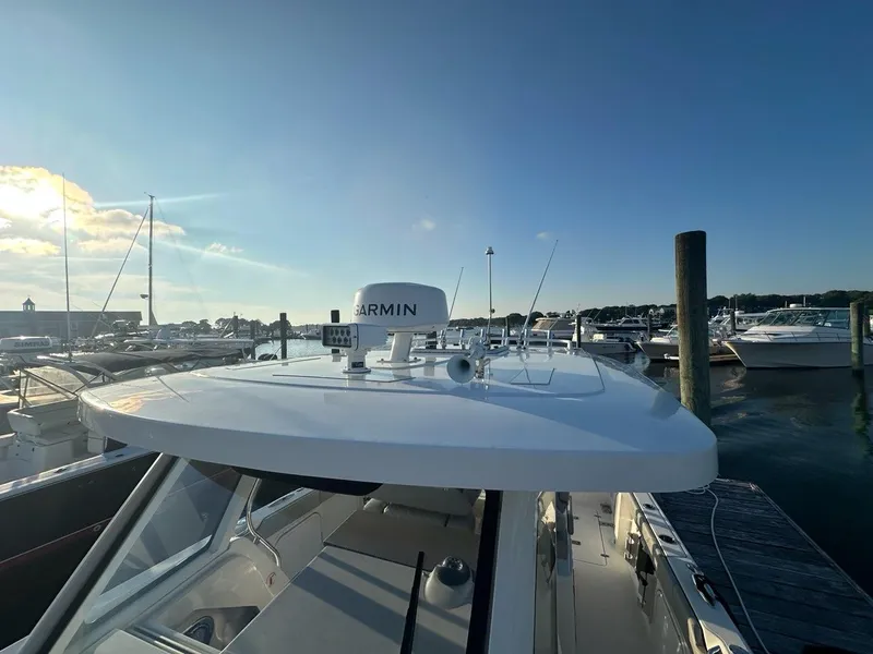Slide: The Image of 2022 Pursuit S 328 Sport boat docked at marina under clear blue sky. - 22