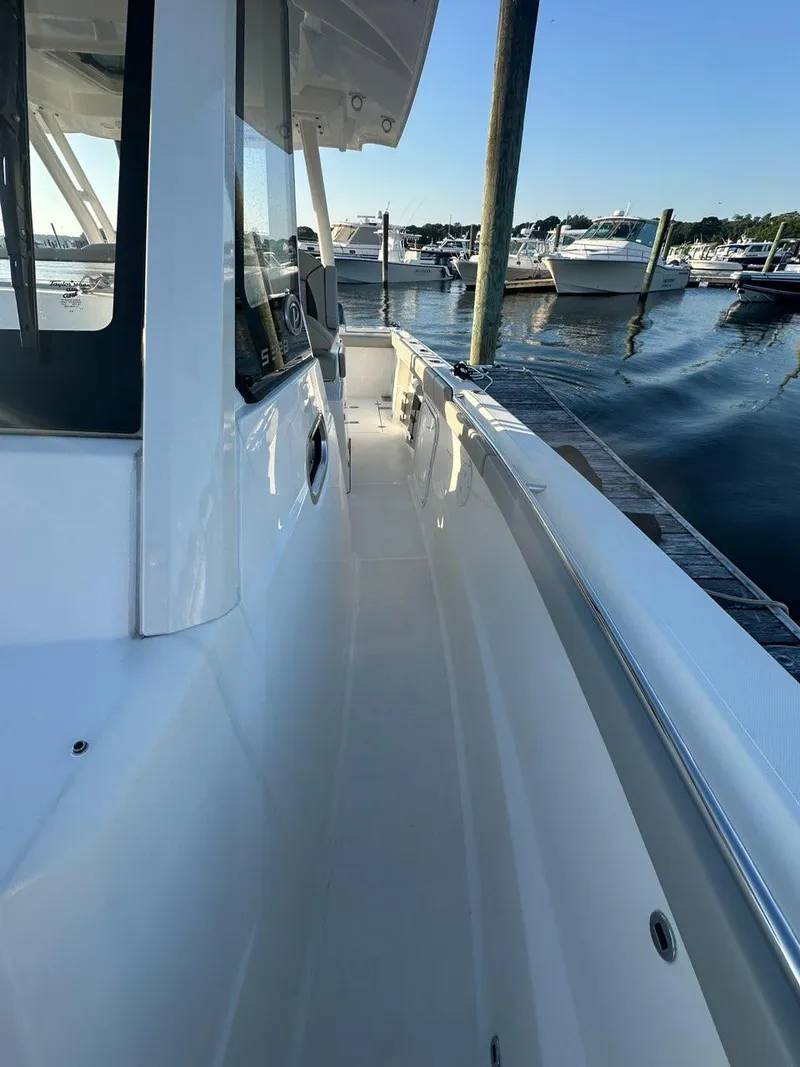 Slide: The Image of 2022 Pursuit S 328 Sport boat docked at marina, side view. - 23