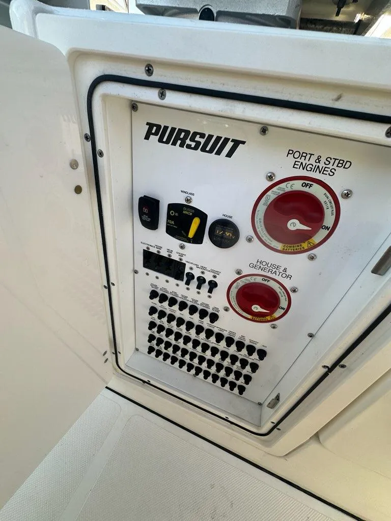 Slide: The Image of Control panel of 2022 Pursuit S 328 Sport boat, featuring engine and generator switches. - 24