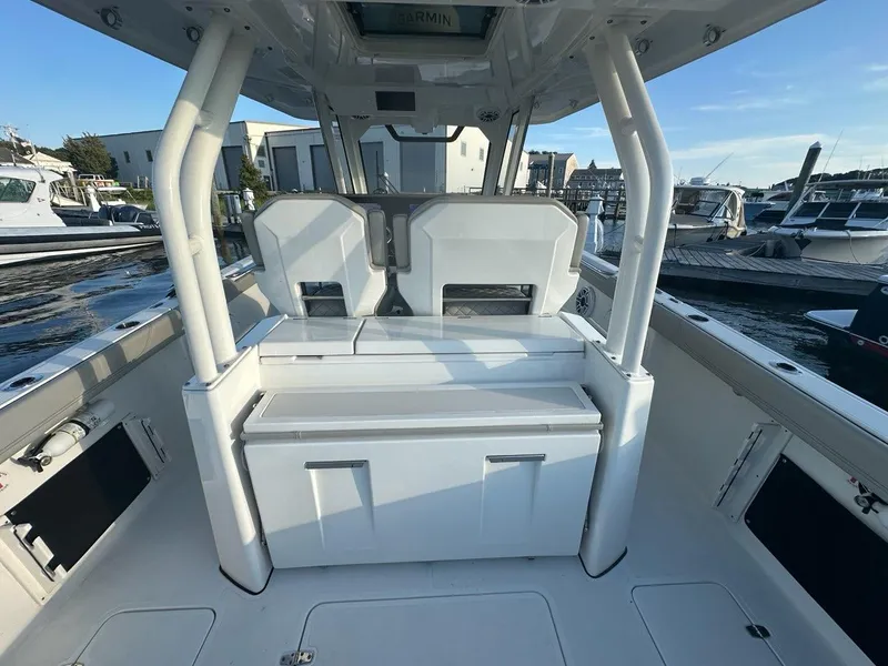 Slide: The Image of 2022 Pursuit S 328 Sport boat interior with seating and storage, docked at marina. - 25