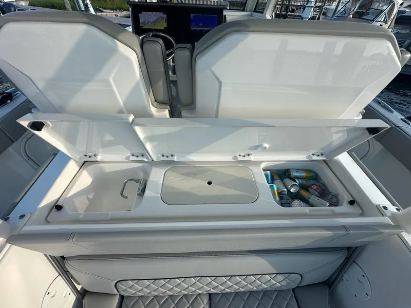 Slide: The Image of 2022 Pursuit S 328 Sport boat with open storage compartment, revealing drinks and ice. - 27