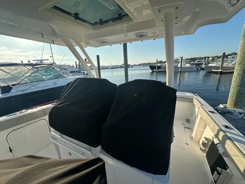 Slide: The Image of 2022 Pursuit S 328 Sport boat interior at marina, covered seats, sunny day. - 3