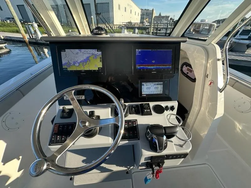 Slide: The Image of Helm of 2022 Pursuit S 328 Sport boat with navigation screens and controls. - 4