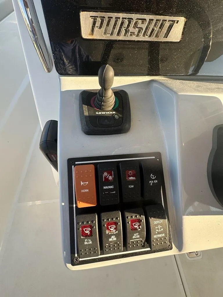 Slide: The Image of Control panel of a 2022 Pursuit S 328 Sport boat with various switches and joystick. - 6