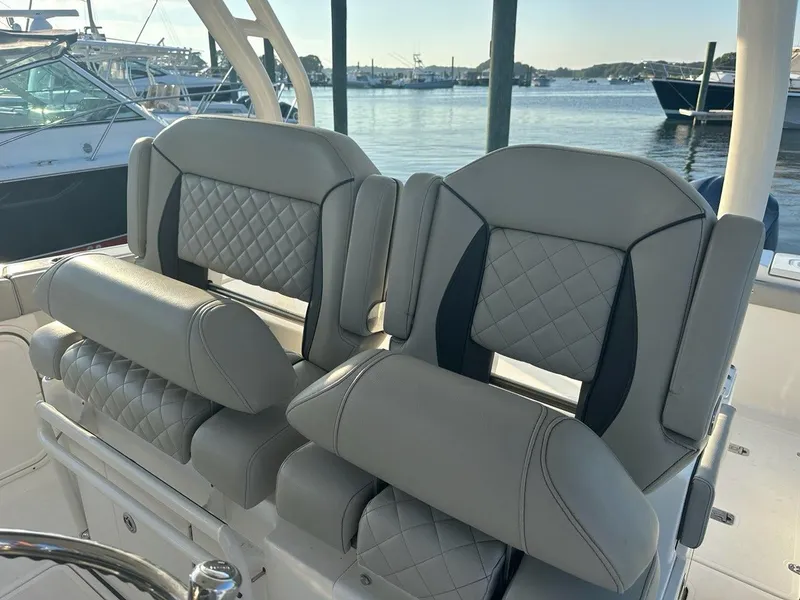 Slide: The Image of Luxury seating on 2022 Pursuit S 328 Sport boat, docked at marina. - 9