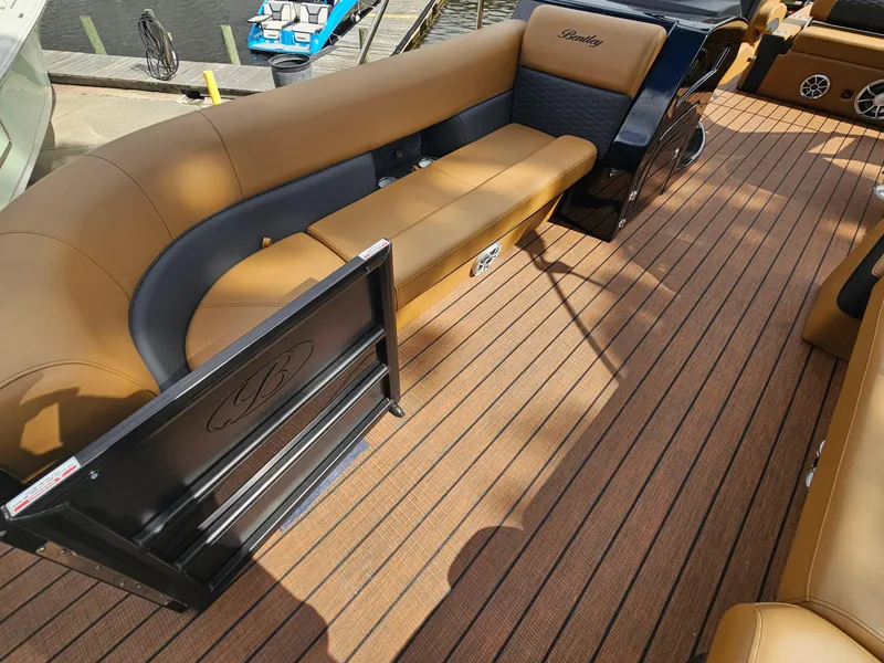 Slide: The Image of 2026 Bentley Pontoons Elite 253 Swingback with luxurious seating and wood-style flooring. - 11