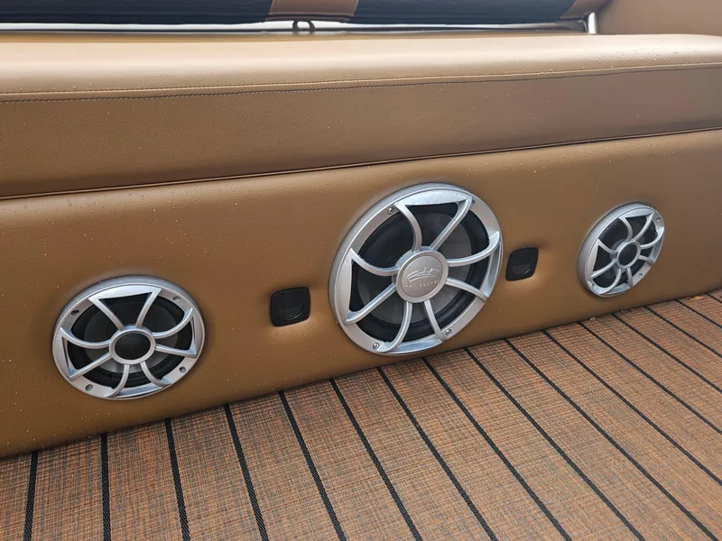 Slide: The Image of 2026 Bentley Pontoons Elite 253 Swingback speakers on tan upholstery, showcasing premium audio design. - 17