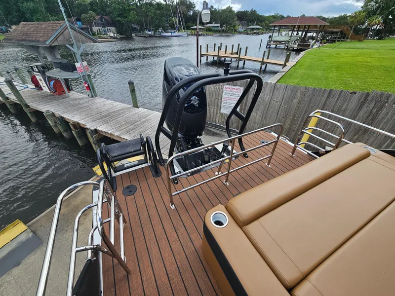 Slide: The Image of 2026 Bentley Pontoons Elite 253 Swingback at dock, featuring luxurious seating and sleek design. - 18