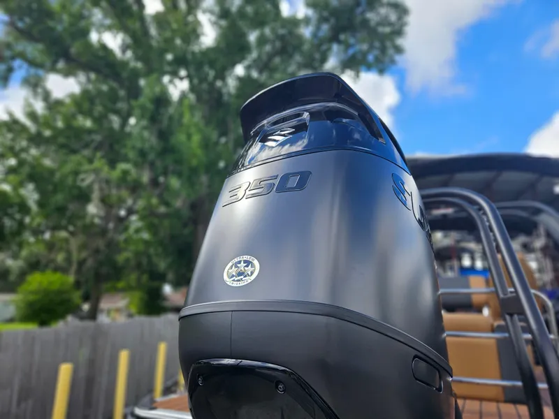 Slide: The Image of 2026 Bentley Pontoons Elite 253 Swingback with luxurious seating on a scenic waterfront. - 2