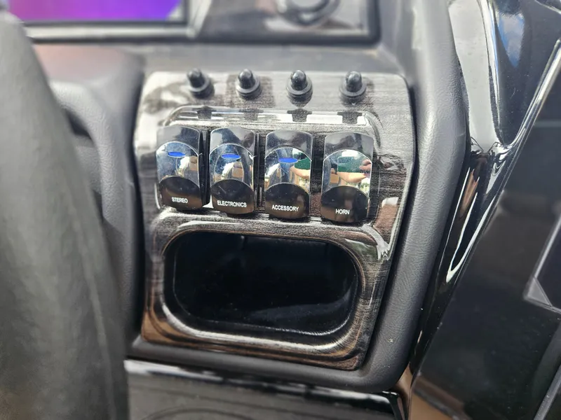 Slide: The Image of Control panel of 2026 Bentley Pontoons Elite 253 Swingback with labeled switches. - 26