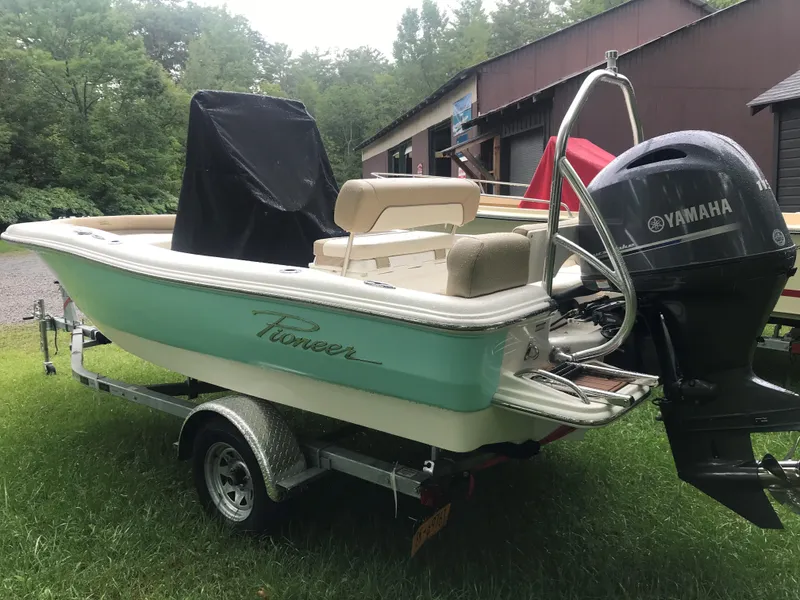Slide: The Image of 2026 Pioneer 180 Islander boat with Yamaha engine on trailer, parked on grass. - 10