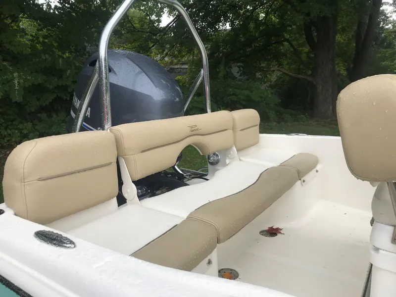 Slide: The Image of 2026 Pioneer 180 Islander boat interior with beige seating and Yamaha engine, outdoors. - 7