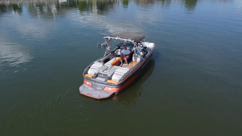 Slide: The Image of 2016 MasterCraft X23 boat on calm water, featuring sleek design and spacious seating. - 6