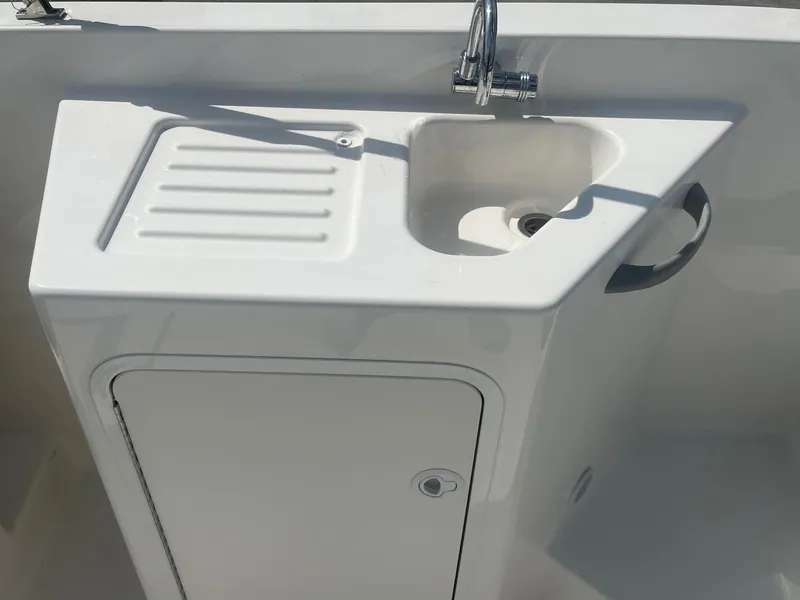 Slide: The Image of 2022 Bayliner DX 2200 boat sink and storage compartment. - 12
