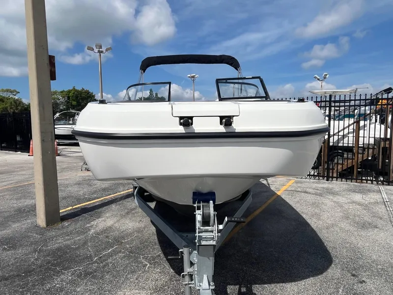 Slide: The Image of 2022 Bayliner DX 2200 boat on trailer under a clear blue sky. - 4