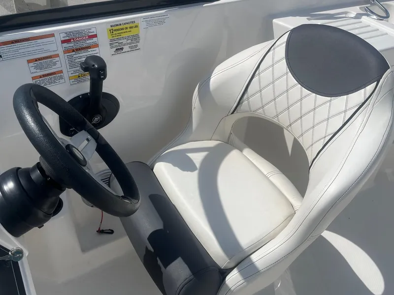 Slide: The Image of Steering wheel and seat of 2022 Bayliner DX 2200 boat cockpit. - 6