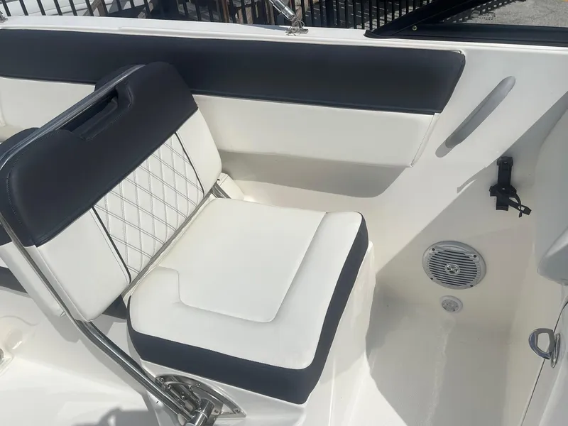 Slide: The Image of 2022 Bayliner DX 2200 boat interior with cushioned seating and speaker. - 8