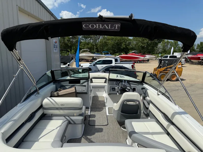 Slide: The Image of 2019 Cobalt CS23 boat interior with seating, steering wheel, and canopy in a sunny outdoor setting. - 11