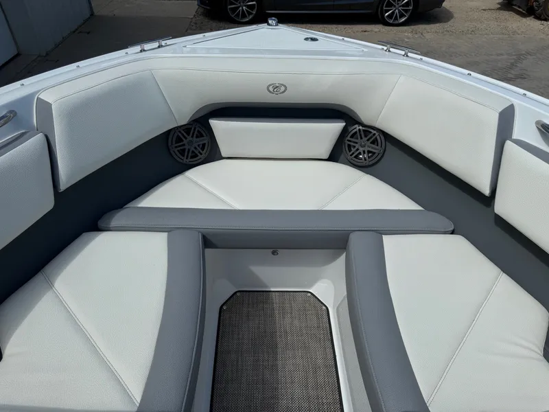 Slide: The Image of 2019 Cobalt CS23 boat interior with white and gray seating, featuring built-in speakers. - 12