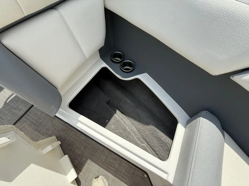 Slide: The Image of 2019 Cobalt CS23 boat interior storage compartment with cup holders and cushioned seating. - 17