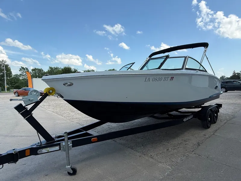 Slide: The Image of 2019 Cobalt CS23 boat on trailer under clear blue sky. - 2
