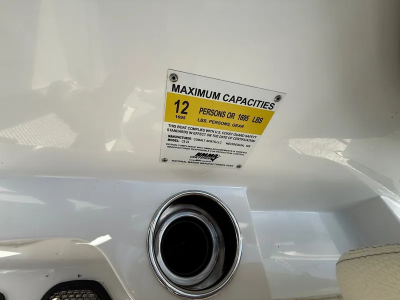 Slide: The Image of 2019 Cobalt CS23 boat capacity label, 12 persons or 1695 lbs, compliance details. - 23