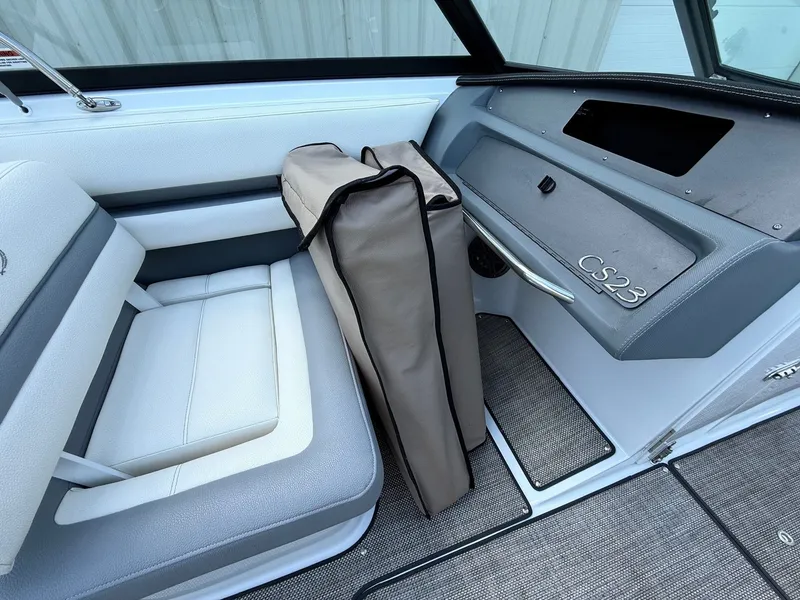 Slide: The Image of 2019 Cobalt CS23 boat interior with cushioned seating and storage compartment. - 26