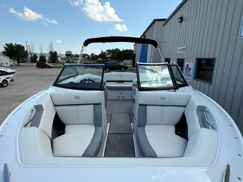 Slide: The Image of 2019 Cobalt CS23 boat with white interior, docked near a metal building under a blue sky. - 3