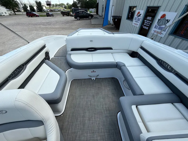 Slide: The Image of 2019 Cobalt CS23 boat interior with white and gray seating, parked outside a building. - 31