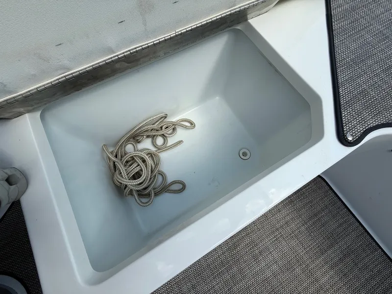 Slide: The Image of Storage compartment with rope in a 2019 Cobalt CS23 boat. - 32