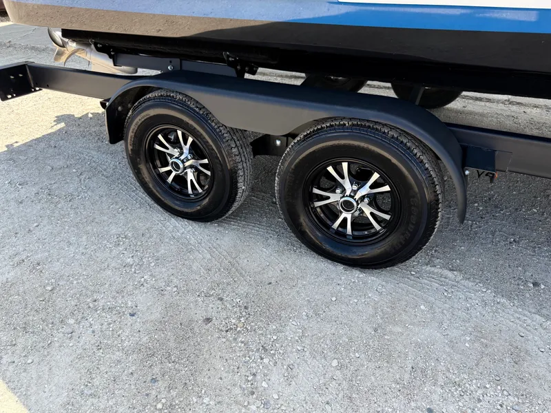 Slide: The Image of Trailer wheels of a 2019 Cobalt CS23 boat on gravel surface. - 41