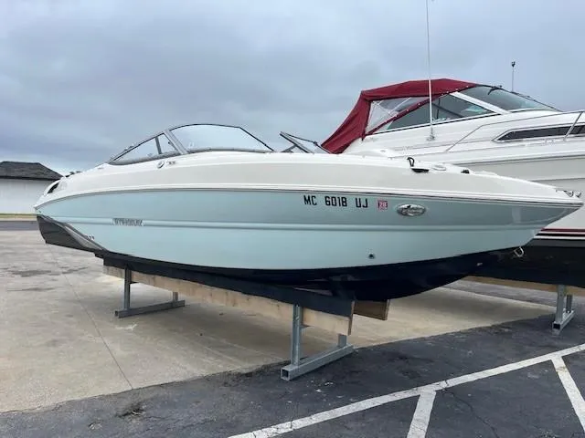 Slide: The Image of 2018 Stingray 235 LR boat on display, parked on a stand in a marina. - 1