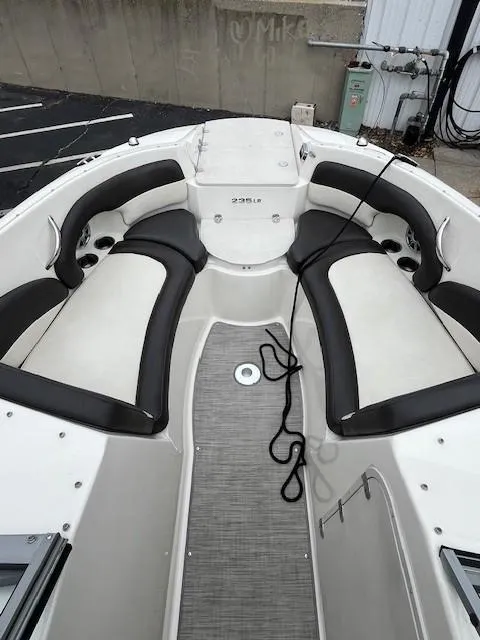 Slide: The Image of 2018 Stingray 235 LR boat interior with cushioned seating and sleek design. - 12